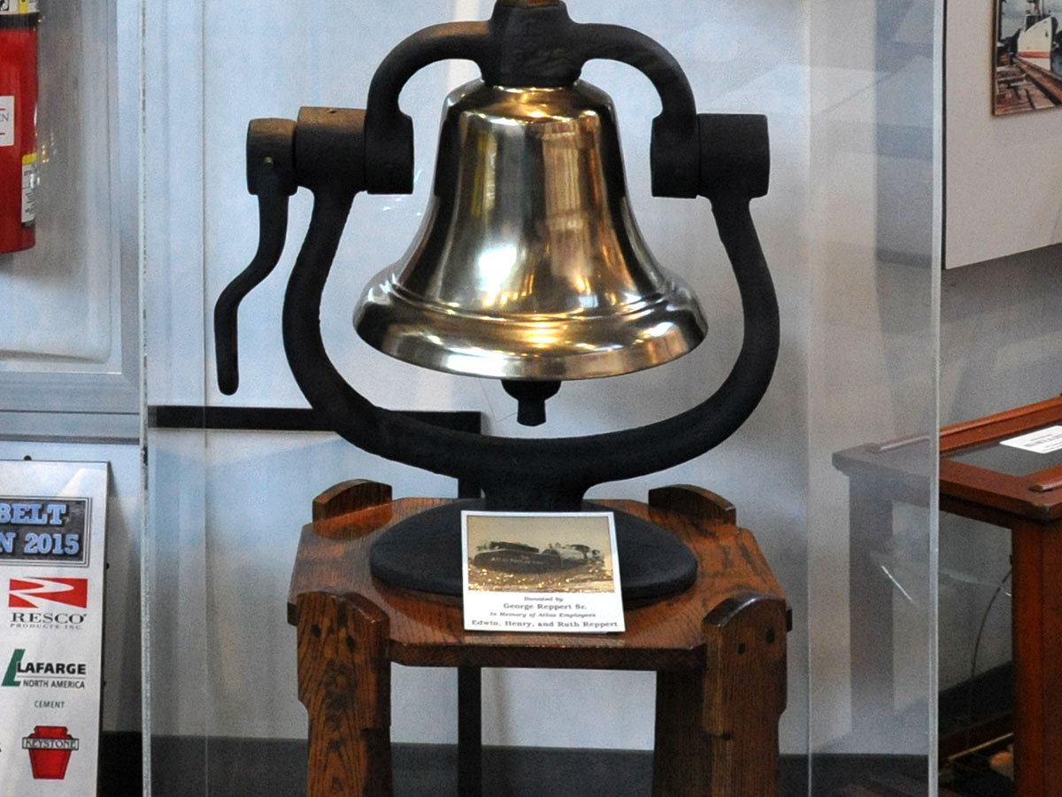 A large brass bell displayed at the Atlas Cement Company Memorial Museum
